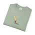 Folded green t-shirt with a windsurfing design and 'Catch the Wind' text on a white background